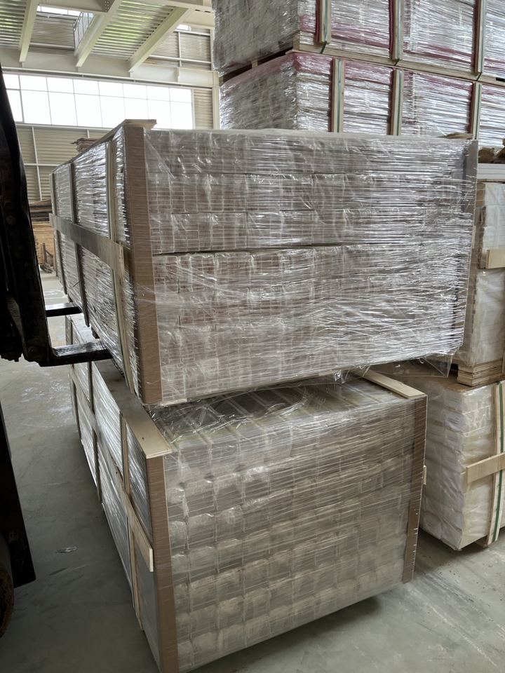 Forklift handling wrapped palletized goods in the factory warehouse