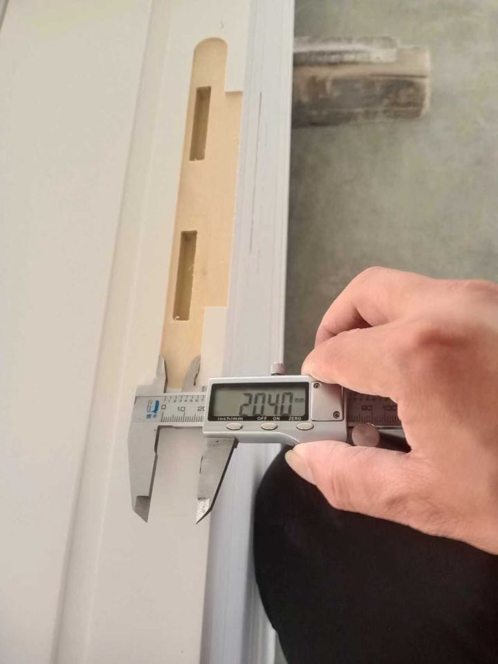 Digital caliper checking a machined groove on a finished wood profile